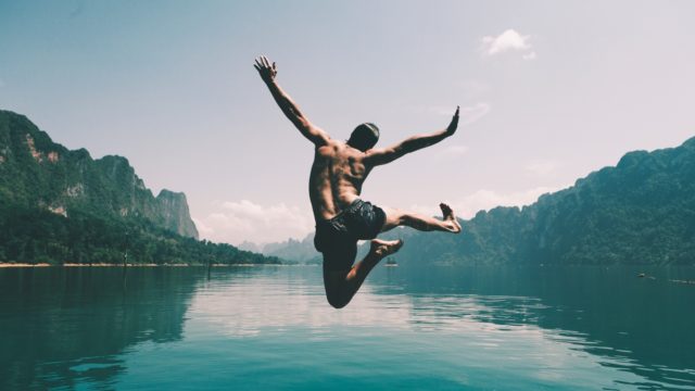 man-jumping-with-joy-by-lake (1) godišnji odmor