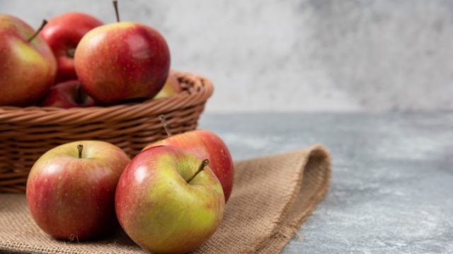 wicker-basket-ripe-shiny-apples-marble-surface-1