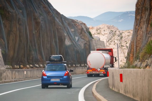 Rear,View,Of,Car,And,Tank,Truck,Driving,Over,Krk